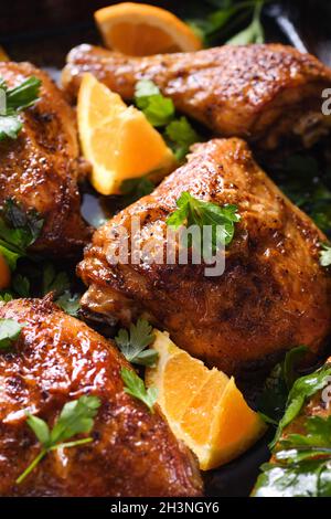 Appetitose fette di pollo al forno con crosta fritta croccante e arance in una teglia da forno Foto Stock