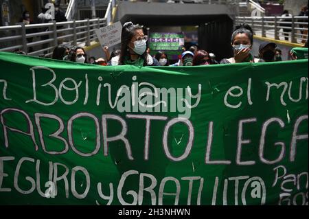 La Paz, Bolivia. 29 ottobre 2021. Le donne che indossano coperture verdi bocca-a-naso ondano sciarpe verdi durante un raduno fuori della conferenza episcopale come parte delle discussioni riguardanti il caso di una ragazza violentata di 11 anni che i mezzi di comunicazione boliviani riferisce è incinta da suo bisnonno passo. La ragazza voleva subire un aborto nel suo quinto mese di gravidanza. Tuttavia, dopo un'offerta di aiuto da parte della Chiesa cattolica, la famiglia cambiò idea, si diceva. Credit: Radoslaw Czajkowski/dpa/Alamy Live News Foto Stock