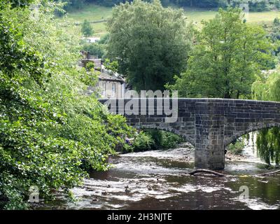 Vista sullo storico ponte a cavallo nella città di hebden Bridge nello yorkshire occidentale circondato da alberi estivi Foto Stock