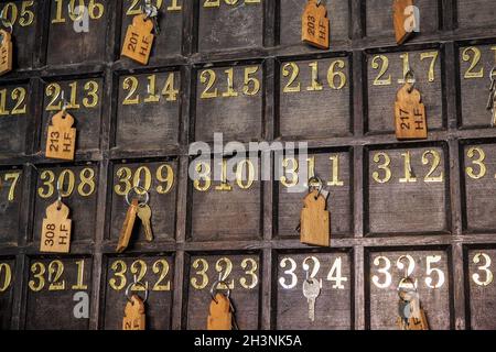 Parete alla reception dell'hotel con chiavi numerate appese su ganci Foto Stock