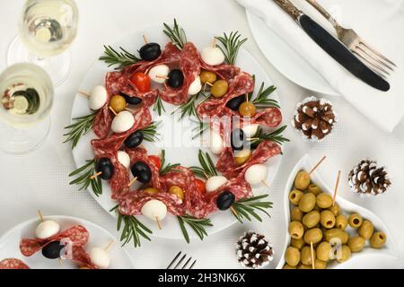 Corona di Natale - antipasto. Tartine di salame con olive, mozzarella. Foto Stock