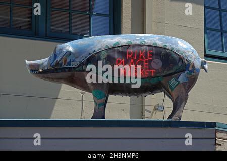 Seattle, WA / USA - 25 giugno 2021: Una statua di maiale con un cartello al neon incorporato viene mostrata al famoso mercato agricolo Pike Place durante una giornata estiva. Foto Stock