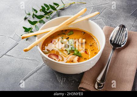 Tom Yam kung piccante zuppa tailandese con gamberi, pesce e frutti di mare, il latte di cocco e peperoncino in vaso Foto Stock