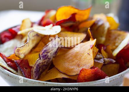 Varietà di patatine colorate in ciotola. Concetto di snack sano Foto Stock