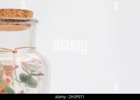 Bouquet di fiori secchi e potpourri in un vaso di vetro su un tavolo bianco Foto Stock