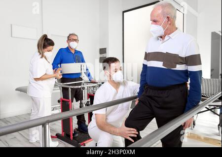 Gruppo di terapisti fisici che lavorano nel centro di riabilitazione, aiutando i pazienti. Foto Stock