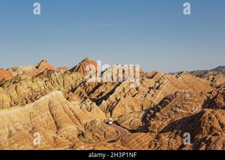 Bel paesaggio collinare e autobus attraverso la strada tortuosa a zhangye Foto Stock