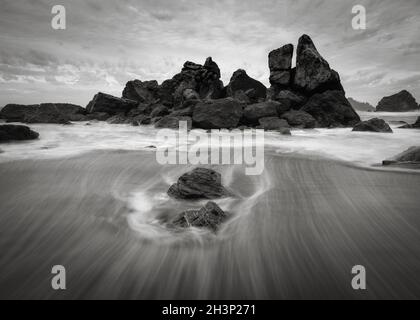 Tramonto a Rocky Beach, costa della California settentrionale, bianco e nero Foto Stock