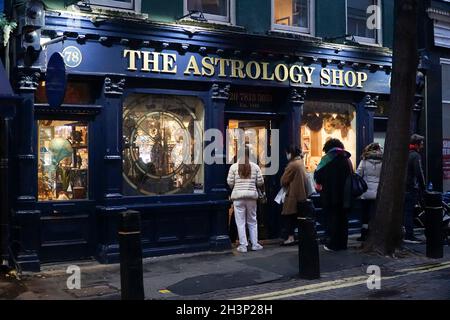 Londra, UK, 29 ottobre 2021: Mentre il crepuscolo cade a Covent Garden e nelle strade acciottolate circostanti, i turisti e gli amanti dello shopping godono di un incantesimo secco tra le docce a pioggia. Le campagne pubblicitarie volte a incoraggiare le persone a visitare Londra sembrano aver attirato molte visite familiari a metà termine e Londra ha attualmente un tasso di infezioni da covid inferiore rispetto ad altre aree del paese. Le decorazioni natalizie sono già in alto nella zona centrale del mercato. Anna Watson/Alamy Live News Foto Stock