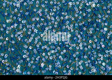 Bellissimo sfondo lucido di paillettes blu. Fondo in tessuto fatto di cerchi blu lucenti. Foto Stock