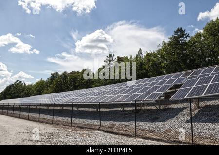 File di pannelli solari dietro una recinzione in Georgia Foto Stock
