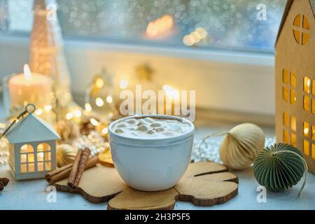Cioccolata calda con marshmallow, cannella e arancia in tazza bianca su sfondo decor di natale Foto Stock