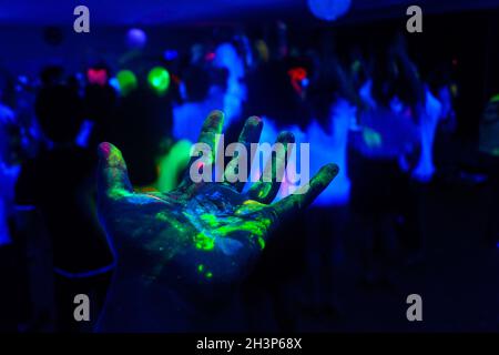 Mano con una vernice fluorescente Foto stock - Alamy