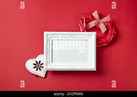 Cornice fotografica e San Valentino cuori e decorazioni su sfondo rosso. Foto Stock