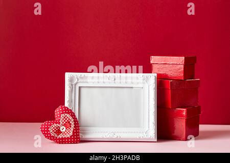 Cornice fotografica e San Valentino cuori e decorazioni su sfondo rosso. Foto Stock