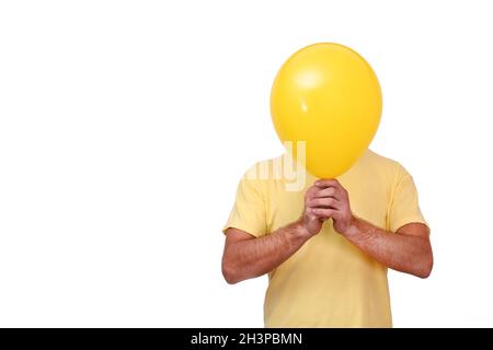 Un uomo tiene un pallone davanti a lui. Sfera gialla che copre il viso. Foto Stock