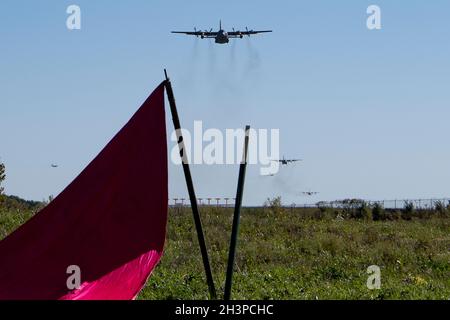 164th Airlift Squadron membri osservano dalla zona di goccia come il C-130H Hercules si avvicina in una formazione di cinque navi come parte di un esercizio di addestramento, 19 ottobre 2021. Il coordinamento di più aeromobili per il volo simultaneo consente ai membri dei gruppi di manutenzione, portuali aerei e operativi di lavorare insieme aumentando la disponibilità complessiva dei membri e delle risorse schierabili. (STATI UNITI Air National Guard foto di Master Sgt. Joe Harwood) Foto Stock