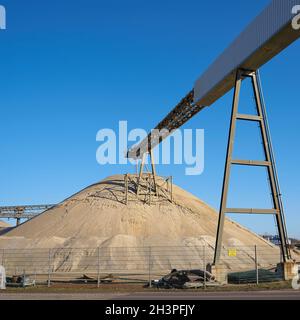 Nastro trasportatore e sabbia estratta in un impianto di ghiaia nel nord della città di Magdeburg in Germania Foto Stock