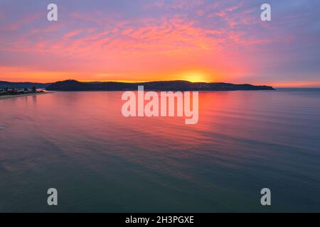 Colorata alba coperta da nuvole a Umina Beach sulla costa centrale, NSW, Australia. Foto Stock