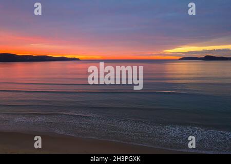 Colorata alba coperta da nuvole a Umina Beach sulla costa centrale, NSW, Australia. Foto Stock