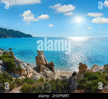 Estate sunshiny mattina piccola spiaggia sabbiosa e rocciosa costa del mare Foto Stock