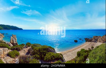 Mattinata estiva sunshiny spiaggia sabbiosa e rocciosa costa vicino a Spiaggia Platanitsi, penisola di Sithonia, Chalcidice, Grecia Foto Stock