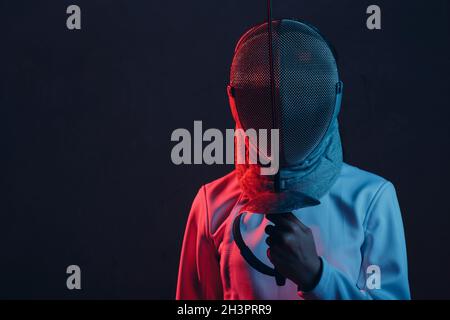 Fencer donna in maschera profilo ritratto con spada scherma, pinza, epee. Foto Stock