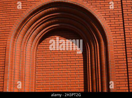 Arch rosso muro di mattoni. Struttura di arco sfondo Foto Stock