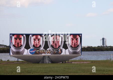 Capo Canaveral, Stati Uniti. 29 ottobre 2021. Uno schermo video mostra i volti dei quattro astronauti di Crew-3 (l-r): Raja Chari, Kayla Barron, Thomas Marshburn e Matthias Maurer davanti a Launchpad 39A, dove il razzo Falcon 9 con la capsula Crew Dragon è già posizionato. (Per il lancio dell'astronauta tedesco Matthias Maurer alla Stazione spaziale Internazionale ISS prevista per il 31.10). Credit: dpa/dpa/Alamy Live News Foto Stock