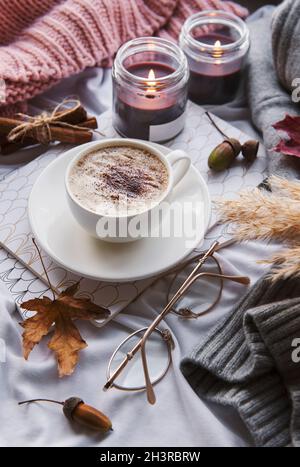 Autunno ancora vita con zucche, caffè e candele brucianti. Composizione autunnale accogliente Foto Stock