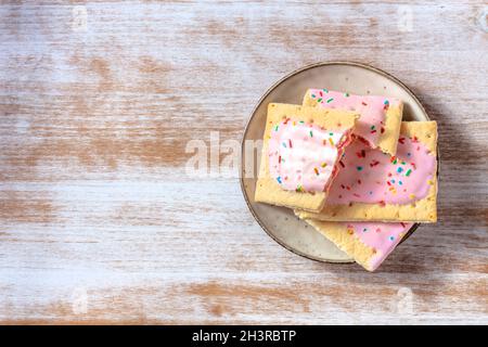 Crostate pop di fragole, sparate dall'alto su un rustico sfondo di legno Foto Stock