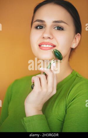 Portait della donna con rullo di giada sul viso Foto Stock