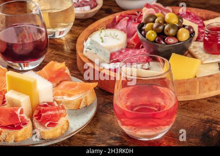 Vino, sandwich, salumi e formaggi su un rustico sfondo di legno Foto Stock