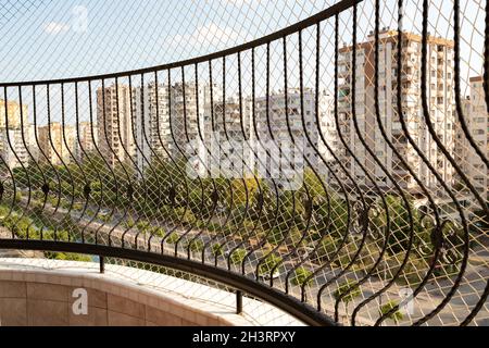 Ringhiere in ferro e rete a rete resistente che proteggono bambini e animali domestici dalla caduta dal balcone. Foto Stock