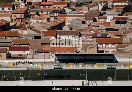 Veduta aerea della piccola città, Consuegra, Castilla la Mancha, Spagna, con attività nel campo di calcio della città Foto Stock
