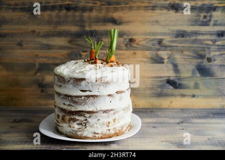 Torta di carote su un piatto su sfondo di legno Foto Stock