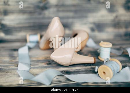 Nastri di seta blu su bobine con le scarpe beige della sposa. Foto Stock