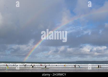 Surfers sulla spiaggia a Newquay Cornovaglia splendida giornata estiva con un vero e proprio doppio arcobaleno sopra l'orizzonte del mare oceano. C'erano tantissimi surf e surf board Foto Stock