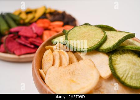 Vista ravvicinata mescolare le patatine di verdure in un recipiente di legno. Foto Stock