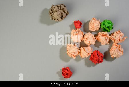 Palle di carta sgualcite su sfondo grigio, vista dall'alto. Il concetto di trovare idee innovative, le soluzioni giuste Foto Stock