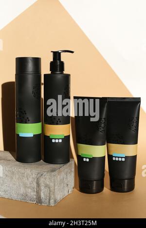 collezione di vari tubi, bottiglie e vasetti per l'igiene di bellezza in cestello su sfondo grigio. cosmetici fatti in casa o professionali per la cura della pelle Foto Stock
