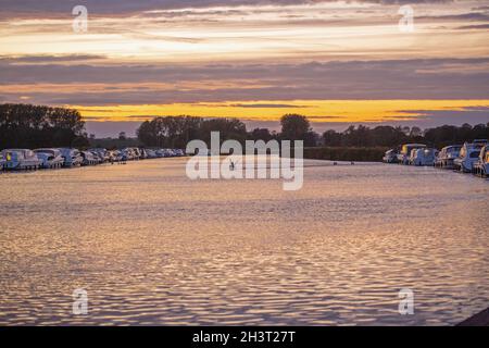 Tramonto serale. Colorati strati di nubi riflessi sulla superficie del fiume Bure, Acle Bridge, Broadland, Norfolk, National Park. Vacanze, vacanze, cruis Foto Stock