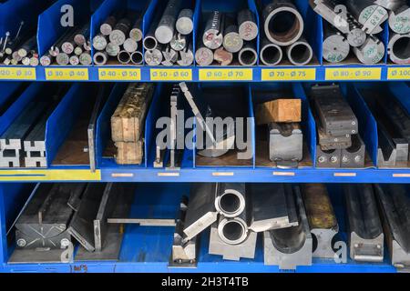 Tubi, pezzi metallici e varie parti metalliche per una macchina CNC in piedi su un ripiano Foto Stock