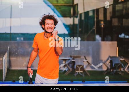 Giocatore di padel che esultava dopo aver vinto una partita - giovane atleta che festeggia la vittoria dopo un buon gioco Foto Stock