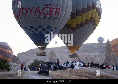GOREME, TURCHIA - 5 AGOSTO 2021: Folle di turisti si riuniscono al mattino per celebrare e scattare foto come mongolfiere stanno decollando a Cappado Foto Stock