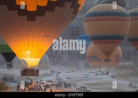 GOREME, TURCHIA - 5 AGOSTO 2021: Folle di turisti si riuniscono al mattino per celebrare e scattare foto come mongolfiere stanno decollando a Cappado Foto Stock