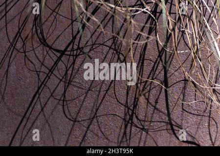 Decorazioni esterne in metallo ruvido con superfici in rilievo e ombre astratte illuminate dalla luce del sole. Foto Stock