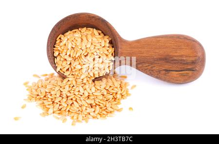 Semi di lino dorato in cucchiaio di legno, isolati su sfondo bianco. Mucchio di semi di lino secchi o di lino. Foto Stock