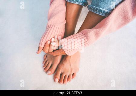 Mani e piedi donna alla moda con manicure francese e pedicure su sfondo bianco con spazio copia. Concetto di banner del salone manicure Foto Stock
