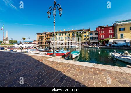 Vecchio e piccolo porto del villaggio di Lazise con molte barche ormeggiate. Famosa località turistica sulla costa del Lago di Garda (Lago di Garda). Verona, Italia. Foto Stock